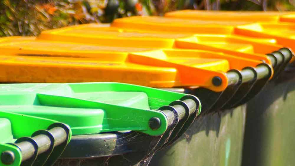 A Line Of Green Waste, Recycled Waste and Trash Rubbish Bins