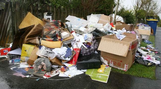 Household rubbish piled on the front yard and footpath waiting to be removed