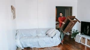 Man removing furniture from his house.